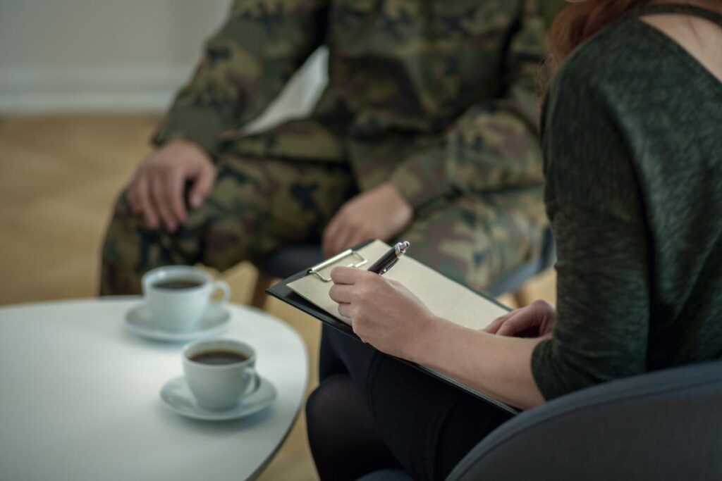 a person listens to a therapist over coffee during alcohol treatment for veterans